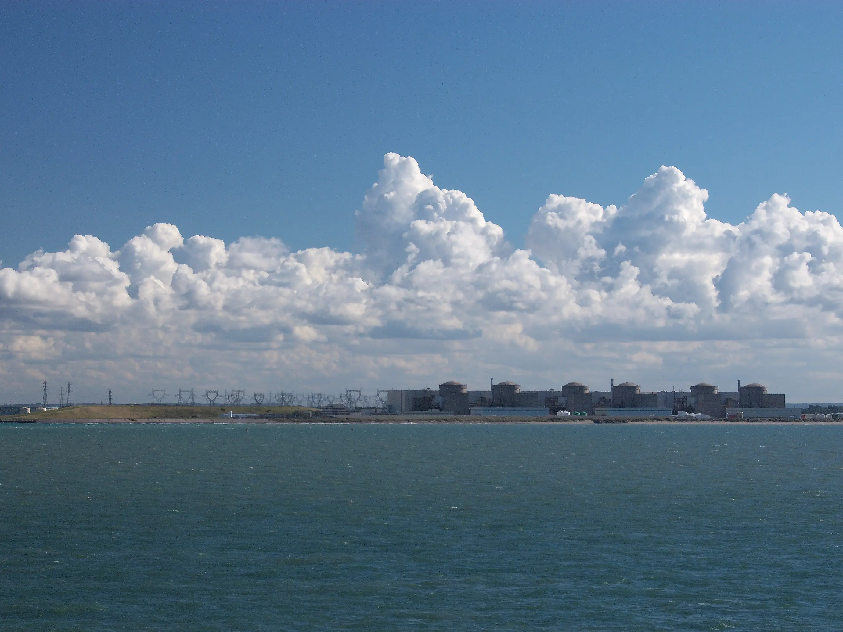 The six reactor buildings of the Gravelines nuclear power station on the French coast, seen from the sea